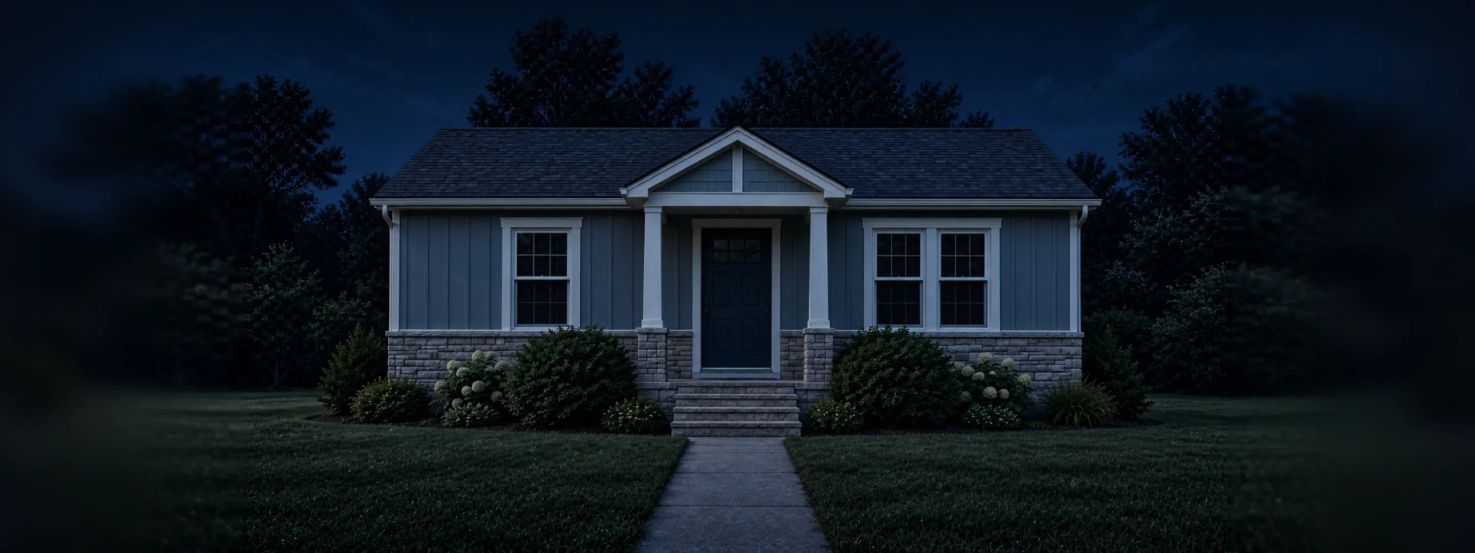 The Kirk house at night with two front windows lit